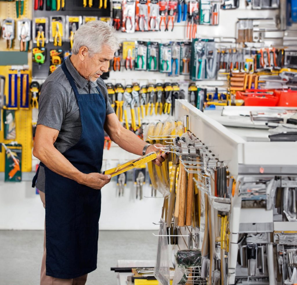Senior man selecting tools in a hardware store.